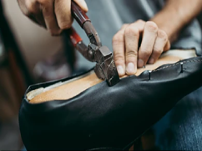 Artisan handcrafting a shoe with precision